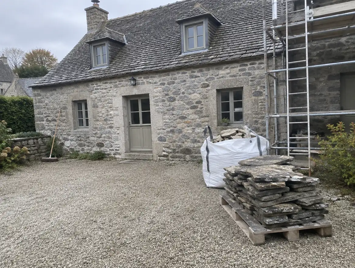Fin de chantier : cour balayée, vieilles lauzes empilées sur une palette
